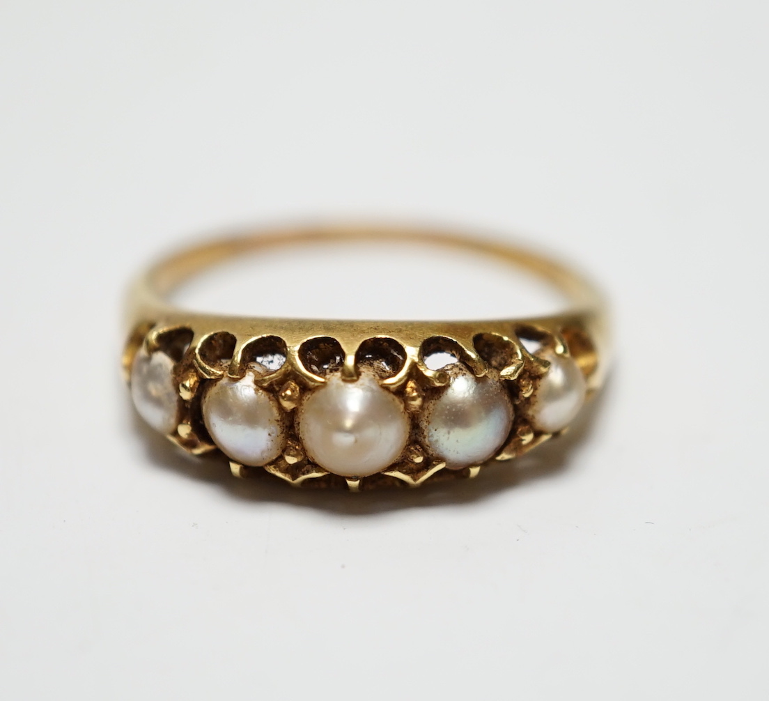 A Victorian yellow metal and graduated split pearl set half hoop ring, size S, gross weight 4 grams.